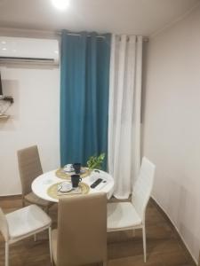 um quarto com uma mesa e cadeiras e uma cortina azul em MareMonti apartments em Castellammare di Stabia