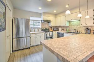 a large kitchen with white cabinets and a stainless steel refrigerator at Horseshoe Bay Townhome with Patio and Outdoor Pool! in Horseshoe Bay