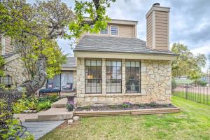 a home with a stone house with a yard at Horseshoe Bay Townhome with Patio and Outdoor Pool! in Horseshoe Bay