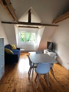 ein Wohnzimmer mit einem Tisch, Stühlen und einem Sofa in der Unterkunft L’appartement du Parc in Longeville-lès-Metz