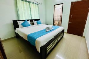 a bedroom with a large bed with blue pillows at TrueLife Comfort Inn - Near PS4 veg restaurant - On way to Balaji Temple - 2BHK AC apartments - Coffee Tea Milk - Fast WiFi, Kitchen, Dining, Android TV, Parking - Easy access to Airport, Railway Station and to all Temples - Top service with lots of Love in Tirupati