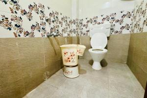 a bathroom with a toilet and a trash can at TrueLife Comfort Inn - Near PS4 veg restaurant - On way to Balaji Temple - 2BHK AC apartments - Coffee Tea Milk - Fast WiFi, Kitchen, Dining, Android TV, Parking - Easy access to Airport, Railway Station and to all Temples - Top service with lots of Love in Tirupati +23 photos