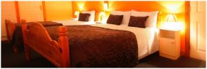 a bedroom with a large bed with white sheets and pillows at McCarthy's Westport in Knockhill and Drinagh