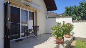 a patio with two plants and a table and chairs at Abigel Thermal Apartman in Bük