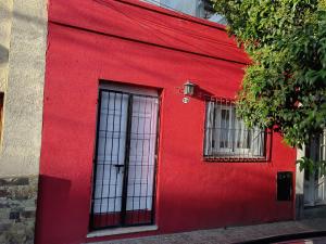 a red wall of a building with two windows at Viajeros in Salta