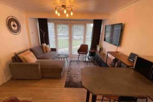 ein Wohnzimmer mit einem Sofa und einem Tisch in der Unterkunft Chalet 130 on Glan Gwna holiday park in Caernarfon
