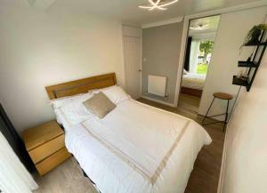 Schlafzimmer mit einem großen weißen Bett und einem Fenster in der Unterkunft Chalet 130 on Glan Gwna holiday park in Caernarfon
