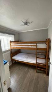 a room with two bunk beds with a ceiling fan at Chalet 130 on Glan Gwna holiday park in Caernarfon