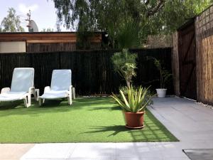 un patio con dos sillas y un parche de hierba artificial en Casa Soleada en Arona