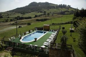 ein Schwimmbad inmitten eines Grasfeldes in der Unterkunft Apartamentos La Gloria in Santillana del Mar