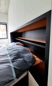 een slaapkamer met een bed met een houten hoofdeinde bij Cofa'sea designvol appartement in Knokke-Heist