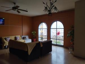 sala de estar con sofá y 2 ventanas en Apartamento frente al Palacio Gobierno, en Lima