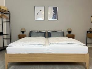 een bed in een slaapkamer met twee foto's aan de muur bij Loft.Wallbox.Garage.Arbeitsplatz.3P.100m zur Mosel in Traben-Trarbach