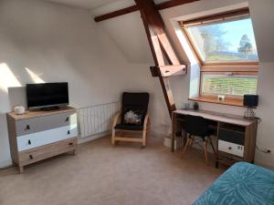 a bedroom with a desk and a bed and a window at Joli Appartement avec vue sur la Baie in Avranches