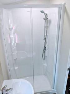 a bathroom with a shower and a sink at Large 4 person Couples and Family Caravan in Newquay Bay Resort in Newquay