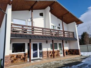 a house with a large deck on the side of it at Cabana Floare de Colt 2 in Râşnov