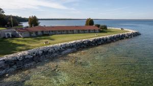 ein Haus am Ufer eines Sees mit einer Steinmauer in der Unterkunft Gordon Lodge in Baileys Harbor