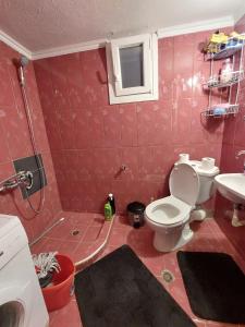 uma casa de banho rosa com um WC e um lavatório em Φιλοξενία1 em Drama