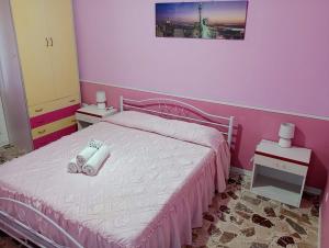 1 dormitorio rosa con 1 cama con 2 toallas en MONGIOVE MARE Pìgna Rossa, en Patti