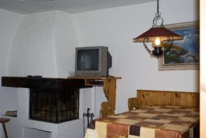 a room with a television on a table with a fireplace at Runatsch in Zernez