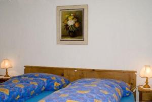 a bedroom with a bed and a picture of a vase of flowers at Runatsch in Zernez
