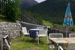 a table and chairs and an umbrella on a patio at Runatsch in Zernez