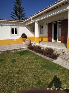 a white and yellow house with a yard at Casinha da Aldeia - country house with swimming pool in Santarém