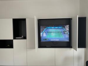 a tv on a wall with a tennis game on it at Cofa'sea designvol appartement in Knokke-Heist