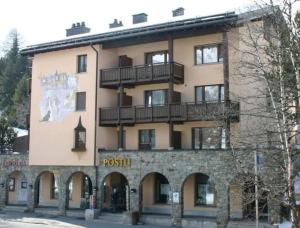 a large building with a sign on the side of it at Apparthotel Pöstli Nr 305 in Maloja