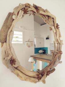 a mirror made out of tree branches on a wall at Brise Marine in Sainte-Luce