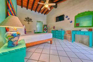 a bedroom with a bed and a tv in a room at Casa Maria Hotel Boutique & Gallery Adults Only in Puerto Vallarta