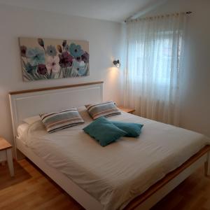 un letto con due cuscini sopra in una camera da letto di Apartments Irena with sea view a Fažana