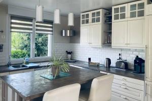 a kitchen with white cabinets and a marble counter top at Cozy'Maisonnette in Guipavas