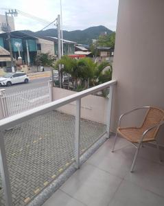 a balcony with a chair and a view of a street at Pousada Show Park in Penha