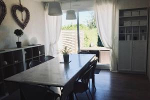 d'une salle à manger avec une table, des chaises et une fenêtre. dans l'établissement Cozy'Maisonnette, à Guipavas