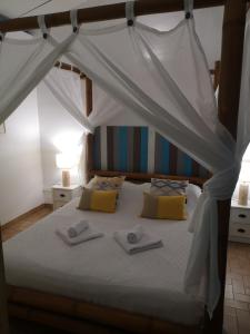 1 dormitorio con cama con dosel y toallas. en Brise Marine en Sainte-Luce