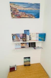 a shelf with books on a wall with a clock at Bella Tao in Taormina +19 photos