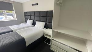 two beds in a small room with a closet at Hosted By Ryan - 2 Bedroom Apartment in Liverpool