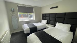 a hotel room with two beds and a window at Hosted By Ryan - 2 Bedroom Apartment in Liverpool