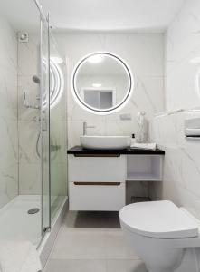 a bathroom with a toilet and a sink and a mirror at ApartamentyGdansk eu Mieszkanie Przylesie in Sopot