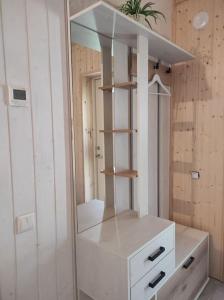 a white cabinet with a mirror on top of it at Luxury countryside house 2 min walk to the beach in Narva-Jõesuu