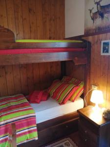 a bunk bed in a wooden room with a lamp and a bed at casa Margherita in Massimeno