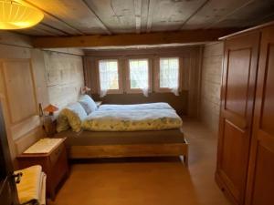 1 dormitorio con 1 cama en una habitación pequeña en Ferienhaus Schönenmatte en Zweisimmen