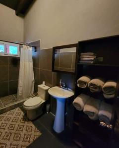 a bathroom with a white toilet and a sink at Bama House hn in Valle de Ángeles