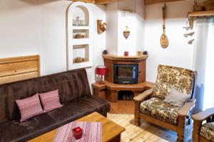 a living room with a couch and a fireplace at Chalupa pod lipou in Oščadnica