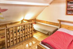 a attic room with a bed and a staircase at Chalupa pod lipou in Oščadnica