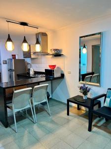 卡塔赫納的住宿－Palmera Beach，厨房配有柜台、椅子和桌子