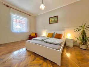 a bedroom with a white bed with orange pillows at Holiday Home Szulok in Szulok