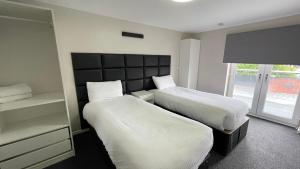 a hotel room with two beds and a window at Hosted By Ryan - 1 Bedroom Apartment in Liverpool