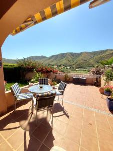 a patio with a table and chairs and mountains at Mi Casa in Turre